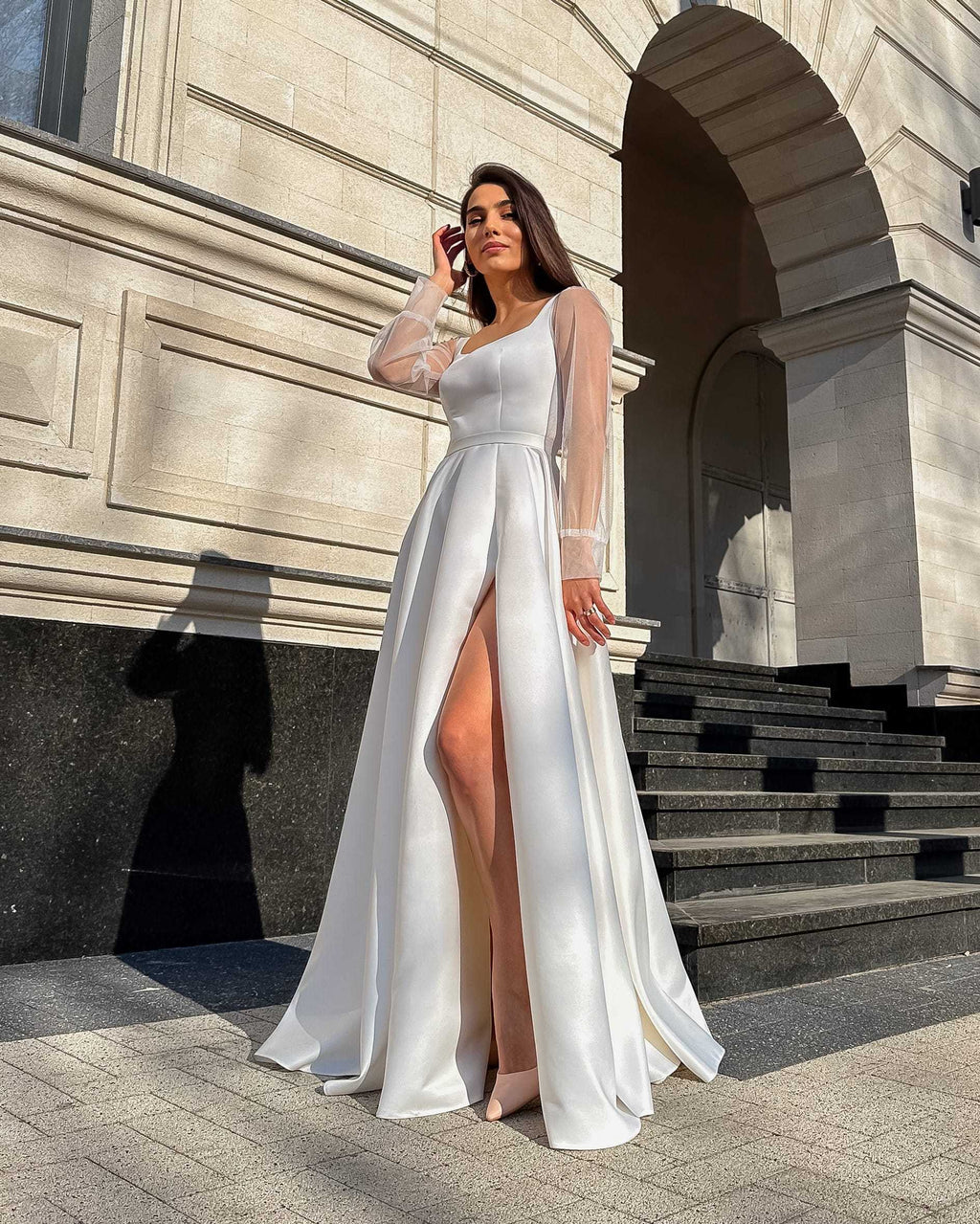 Rochie de mireasa albă lungă din satin regal cu șliț și mâneci transparente din tull.
