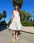 Rochie cununie civila midi alba cu slit si decolteu, din satin regal, stil A-line, fara maneci.