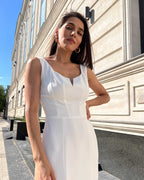 Rochie cocktail albă elegantă fără mâneci, material crep elastic, rafinată și ajustată, cu slit pe piciorul stâng.