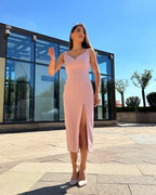 Rochie roz pudrat fără mâneci cu slit pe piciorul stâng, fermoar la spate.