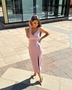 Rochie roz pudrat fără mâneci, cu slit și fermoar la spate.