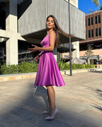 Rochie scurta mov evazată din satin, fără mâneci, decolteu ascuțit, eleganță urbană.