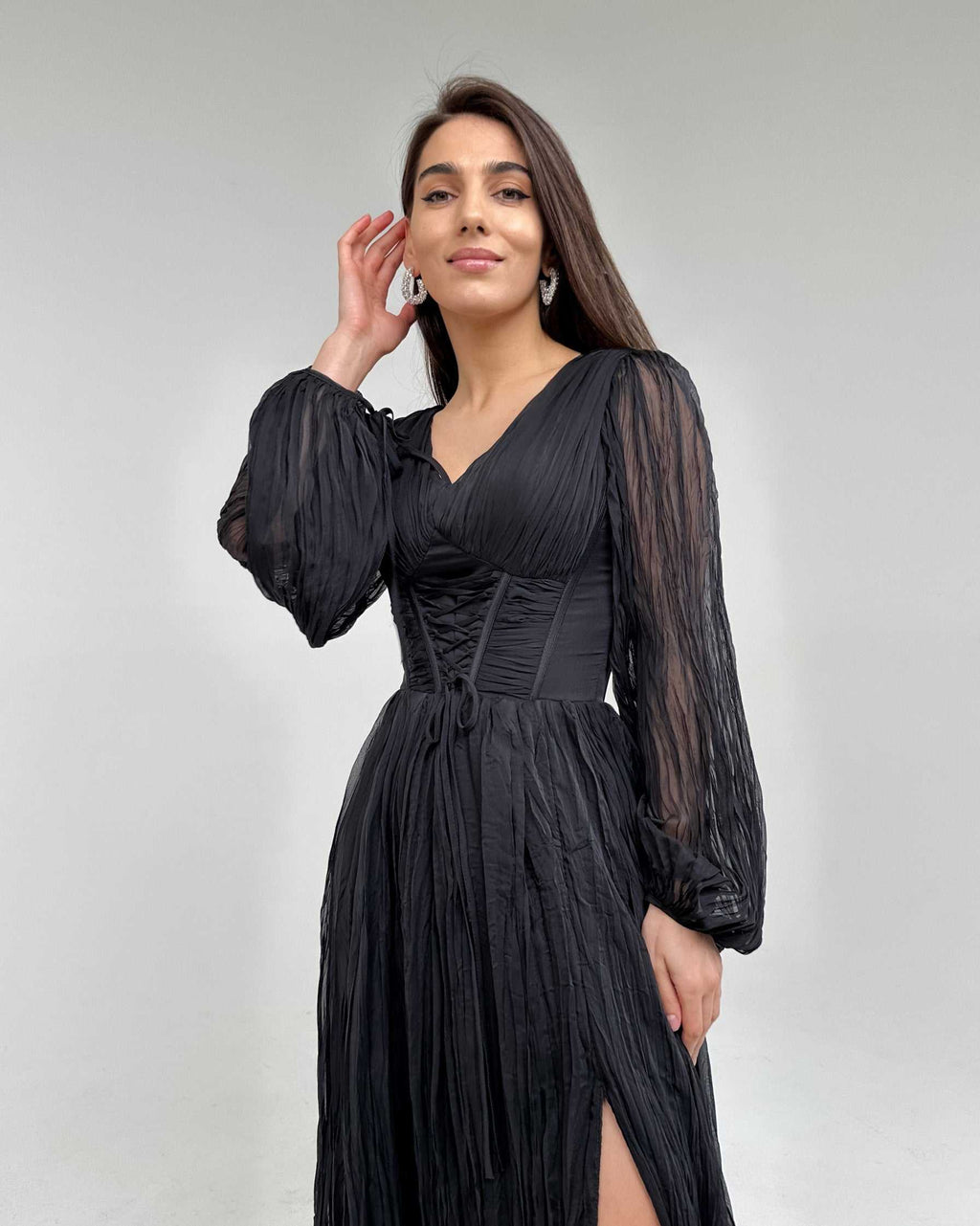 Rochie lunga neagră cu mâneci lungi elegante și șliț, corset evidențiat.