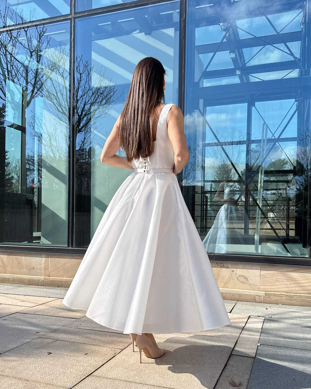 Rochie de mireasa midi albă cu buzunare și centură delicată, design modern și elegant.