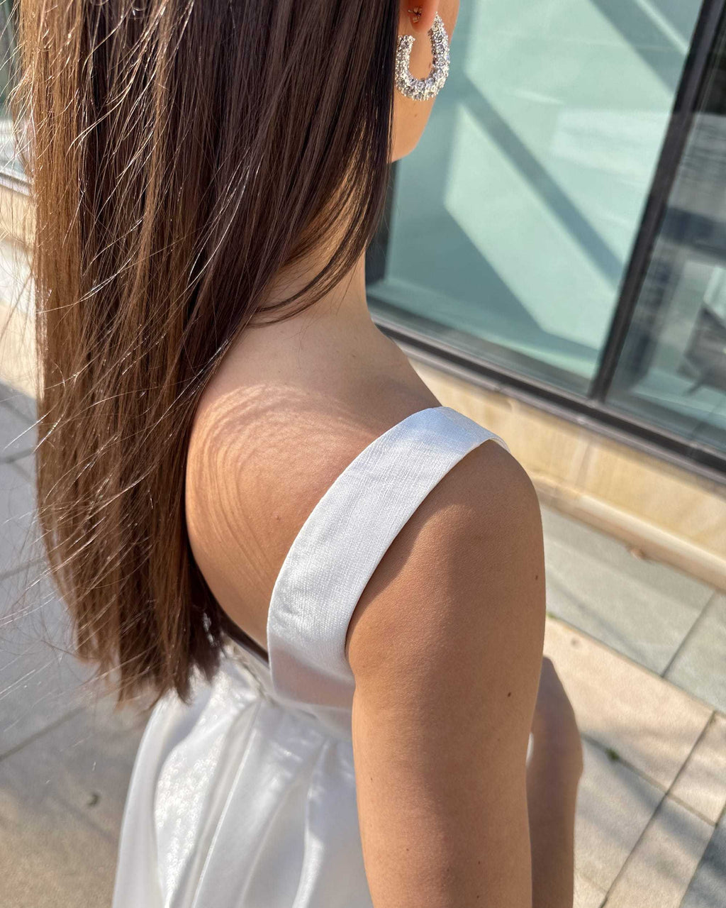 Rochie de mireasa albă elegantă cu buzunare, centură delicată și sistem de închidere cu nasturi.