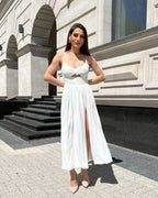 Rochie alba elegantă midi cu slit și bretele, accesorizată cu centură, fermoar la spate.