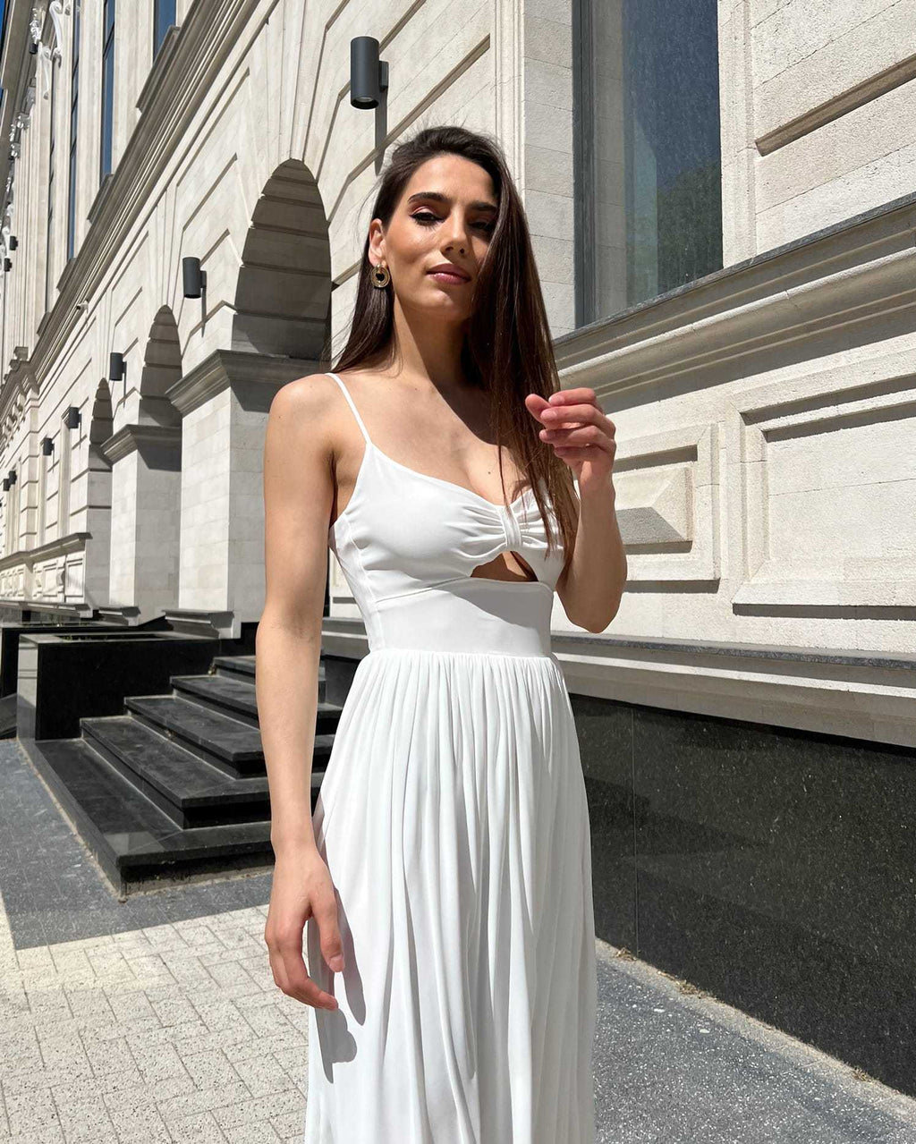 Rochie alba elegantă cu slit și bretele, lungime midi, evidențiază talia, cu fermoar la spate.