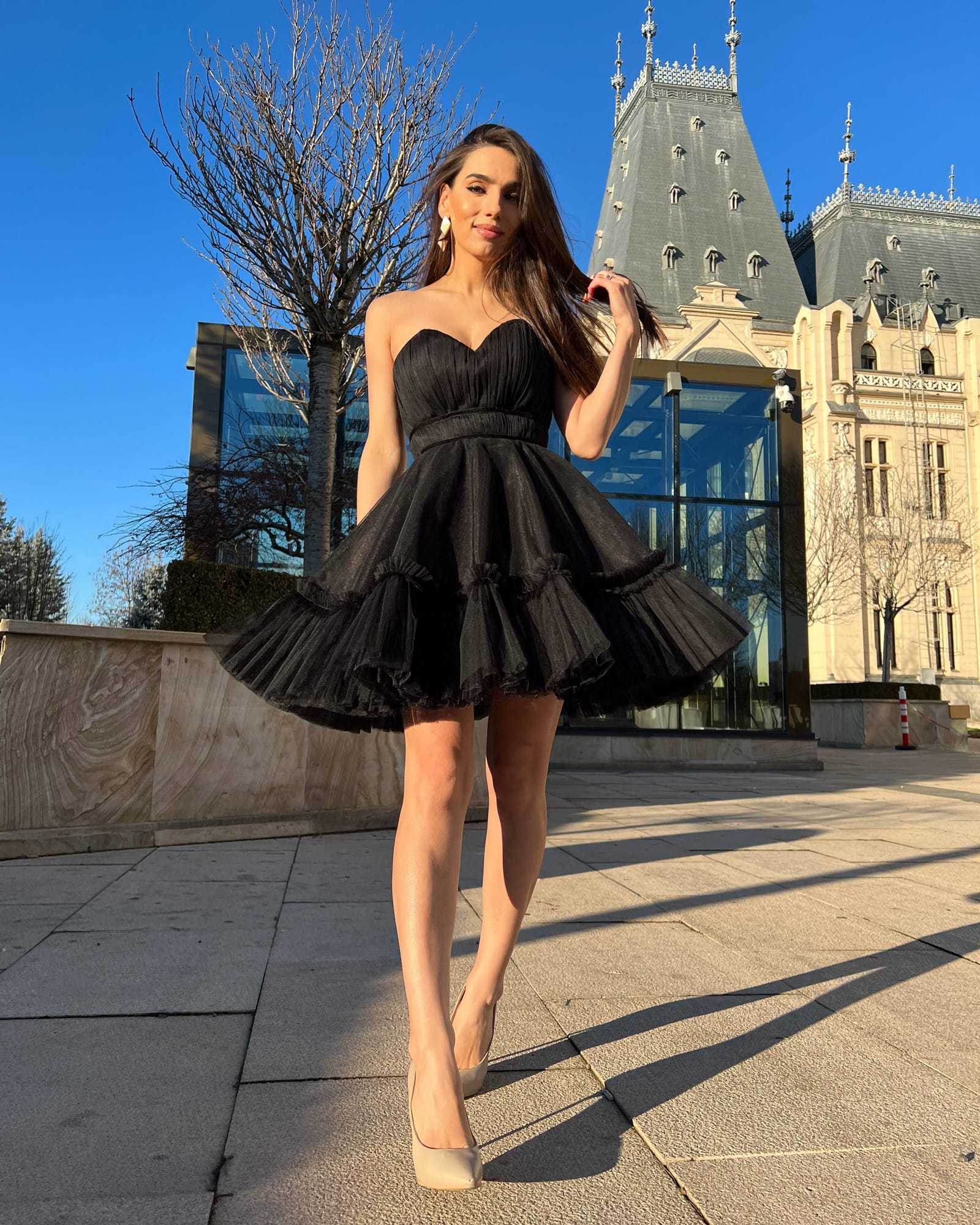 Rochie cocktail scurtă neagră cu corset și fustă evazată, elegantă și feminină.
