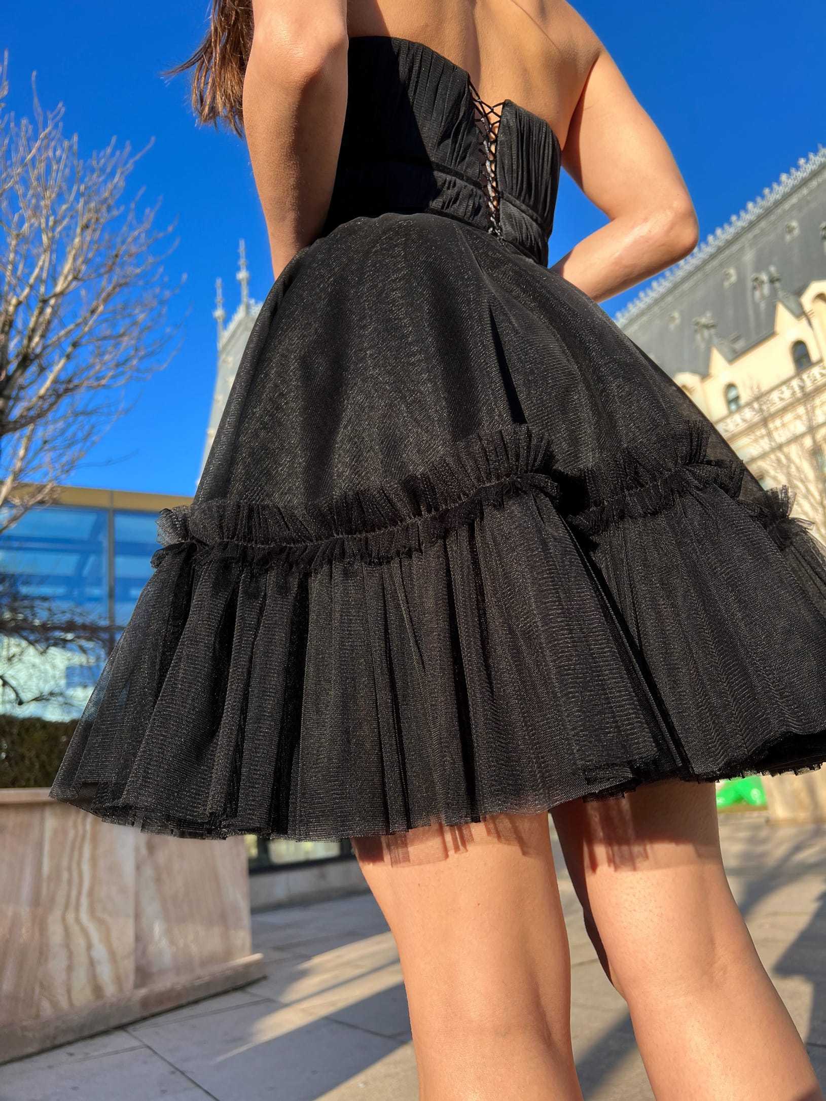 Rochie cocktail elegantă scurtă neagră cu corset și fustă evazată.