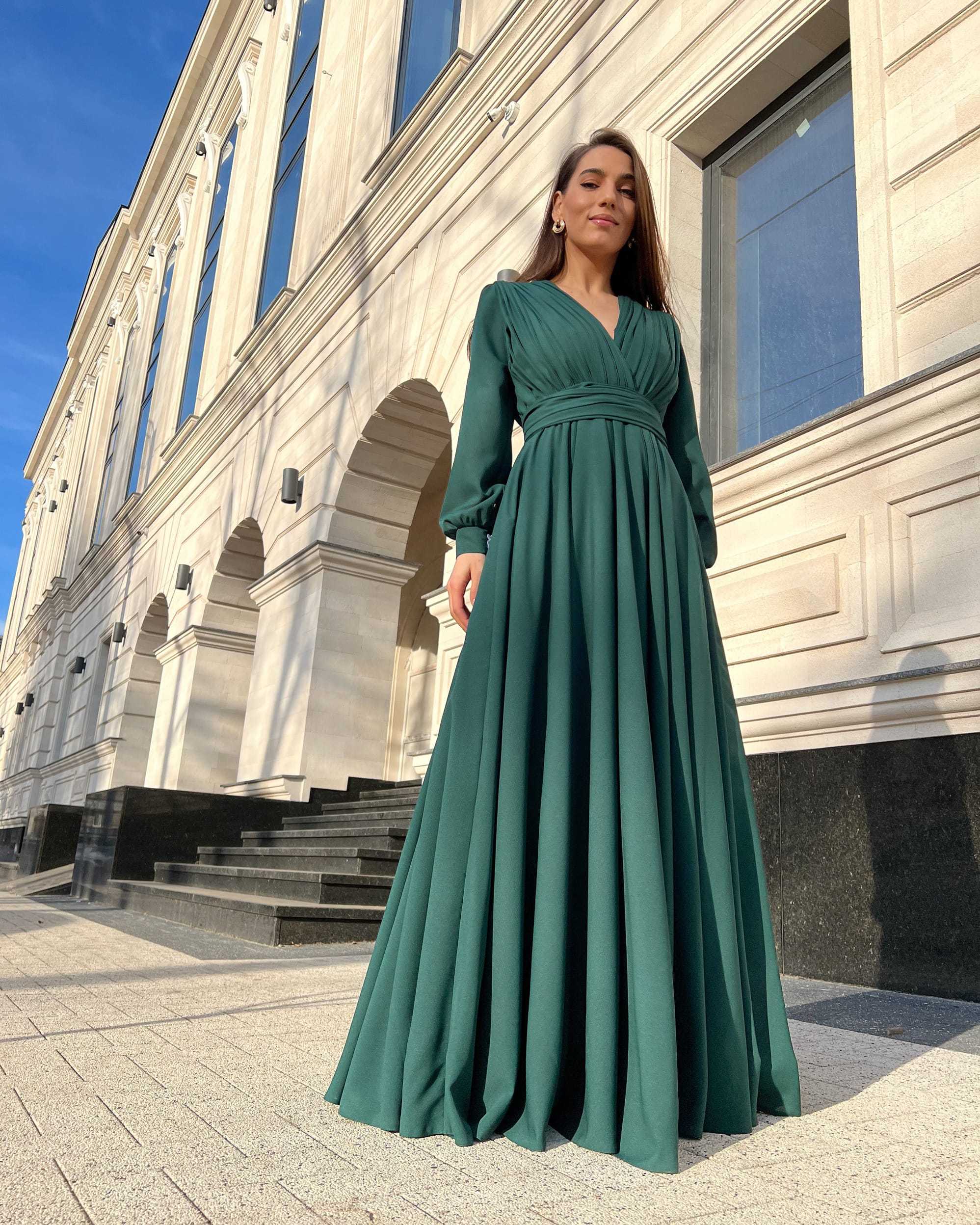 Rochie elegantă de seară lungă din voal verde, cu decolteu în V și mâneci lungi, perfectă pentru evenimente formale.