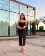 Rochie eleganta de seară neagră cu tăietură centrală, ajustată pe corp, pentru look sofisticat.