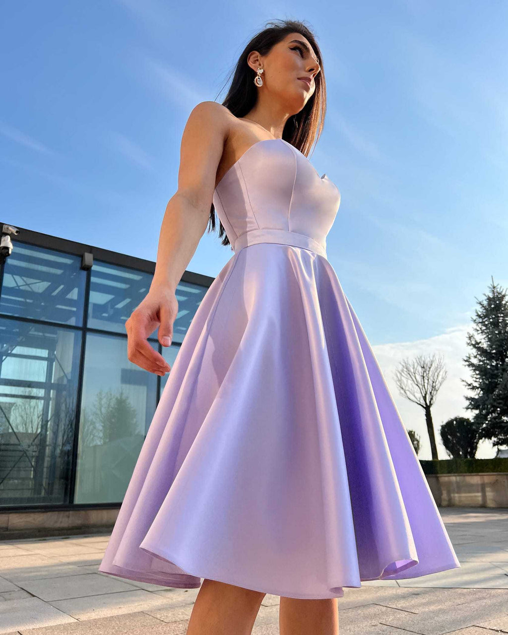 Rochie cu corset midi mov de ocazie și fustă evazată, purtată de o femeie.