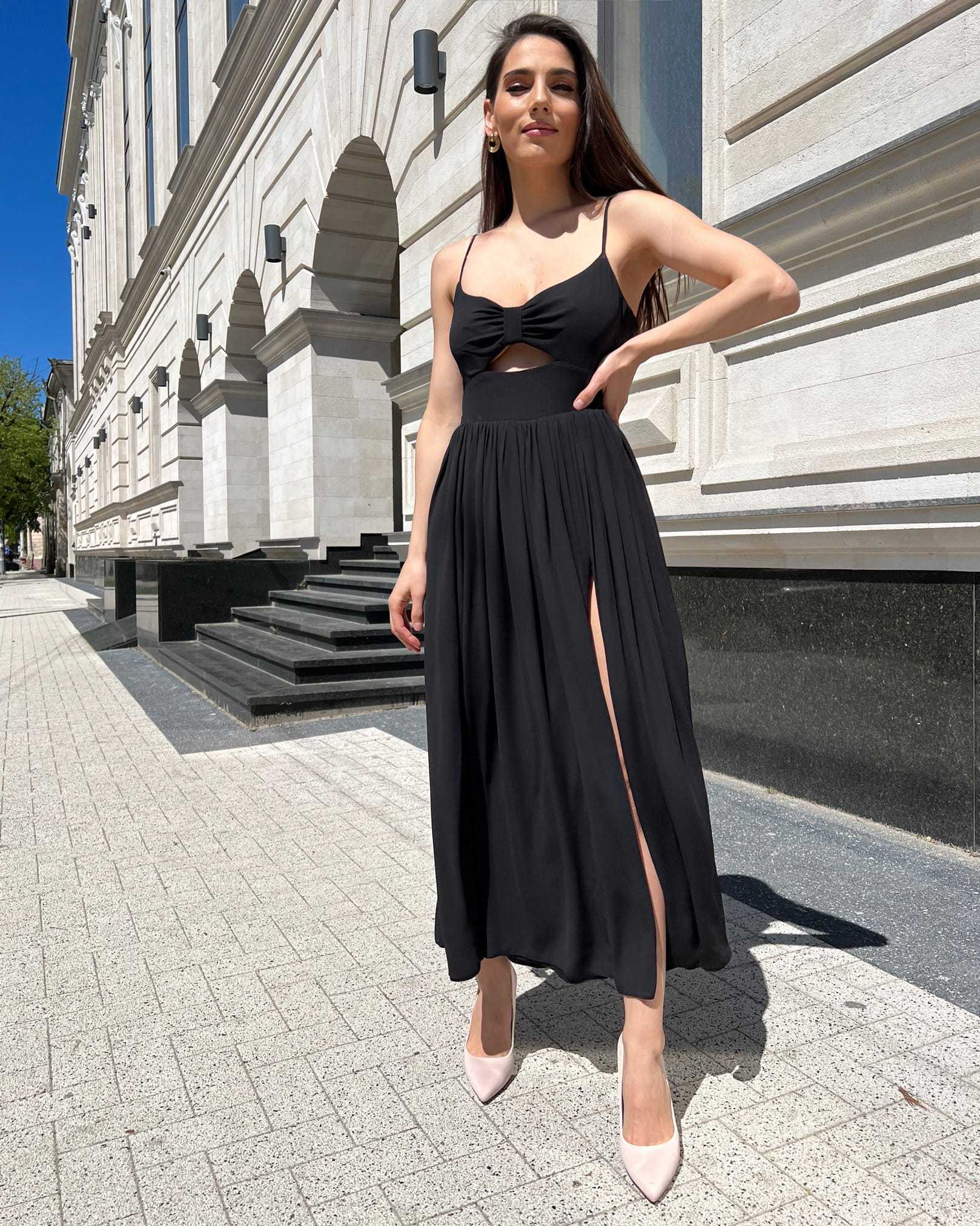 Rochie neagra cu slit și bretele, lungă, cu fermoar la spate.