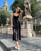 Rochie neagra din catifea cu bandă decorativă din pietre, decolteu și slit dublu.